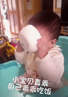小朋友乖乖的自己吃面，把面全部倒在脸上了