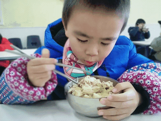 大口吃饭的小男孩