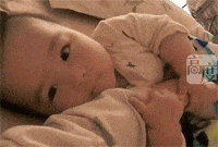 宝宝小手抱着妈妈的大手，笑咪咪的样子太可爱啦