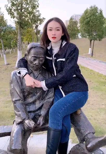 美女坐在铜像身上拍照