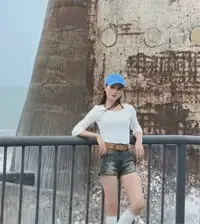站在海边拍照的妹子被海水浇了个透心凉
