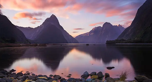 粉紫色的云霞漫过天际，峡湾的镜面便接住了整片温柔的黄昏