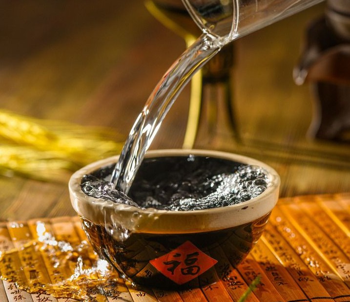 往大碗里倒酒的高清图片