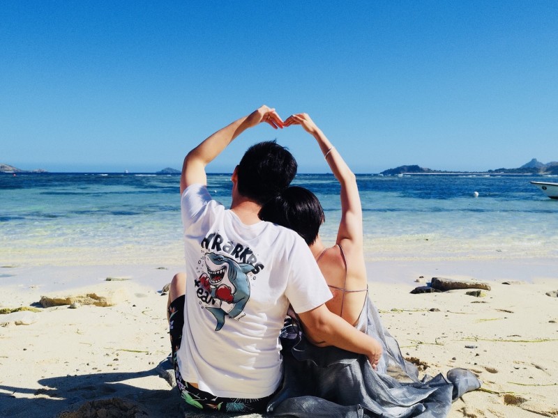 情侣在海边比心的唯美画面