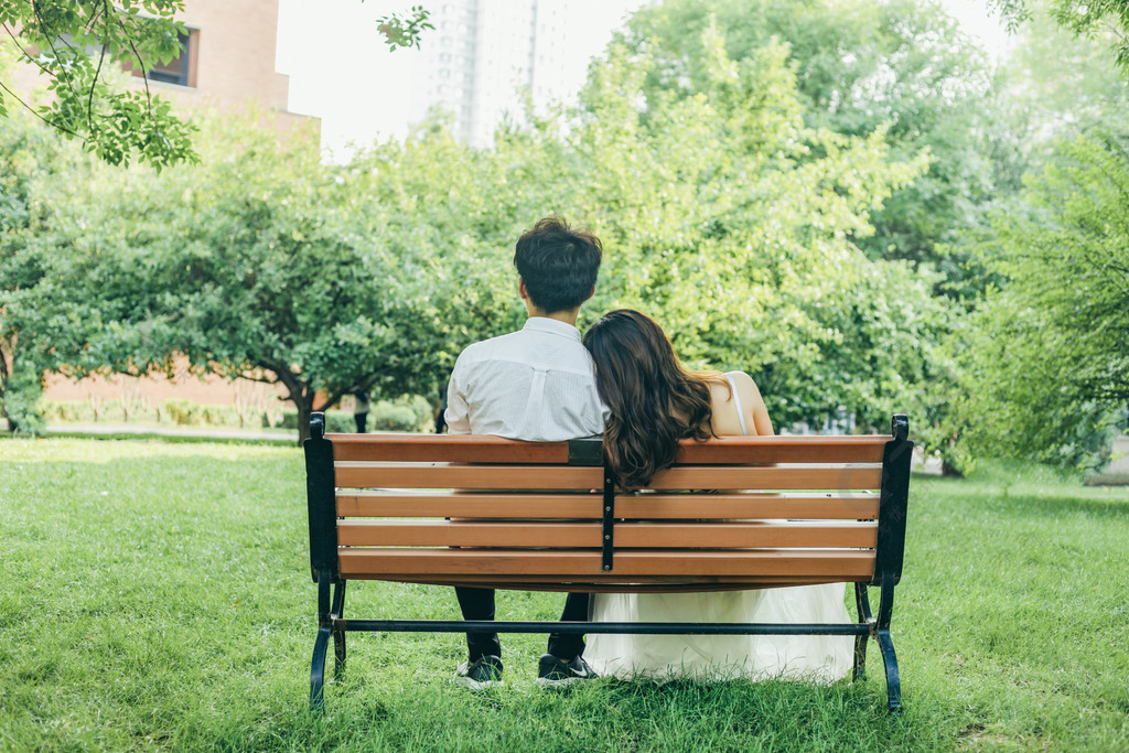 公园里坐在长椅上的情侣背影图