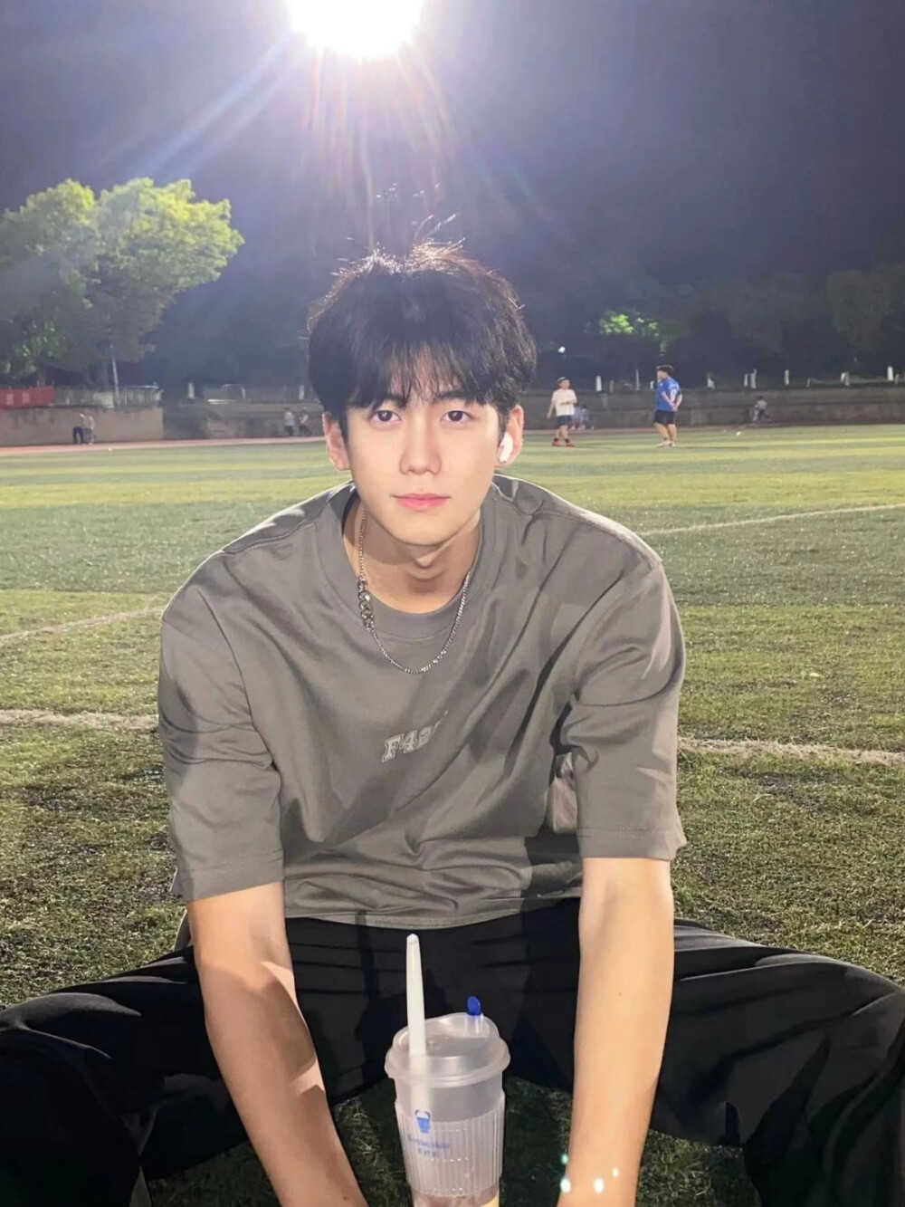 灯光球场上坐着休息的帅哥