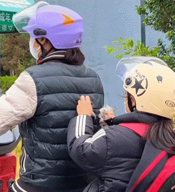 熊孩子坐后面扯妈妈的羽绒服绒子，想不到被偷拍了