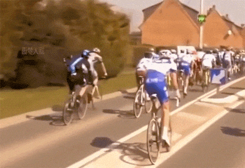 公路自行车比赛选手碰到路标摔翻在地